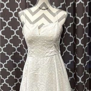 White eyelet dress, side zipper.  Cut out V neck. Embellished back